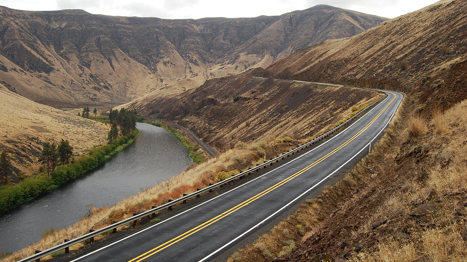 Photo of SR 821 winding along the Yakima River with large hills in the background