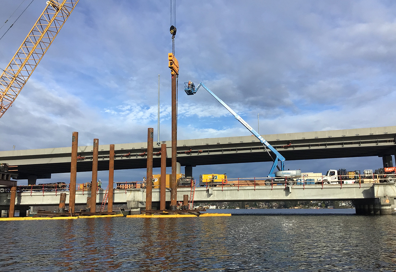 A long, steel pile in Union Bay is vibrated into the lakebed during construction for the SR 520 bridge.