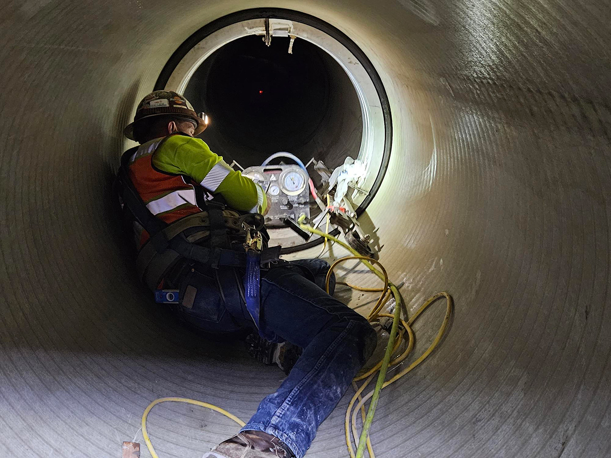 A Seattle Public Utilities worker sits inside a 42 inch wide underground pipe.